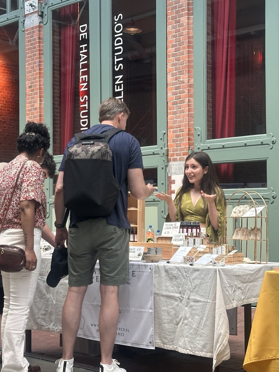 Tara explaining TR Fragrance perfumes to customers at a market stall