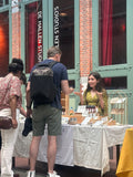 Tara explaining TR Fragrance perfumes to customers at a market stall